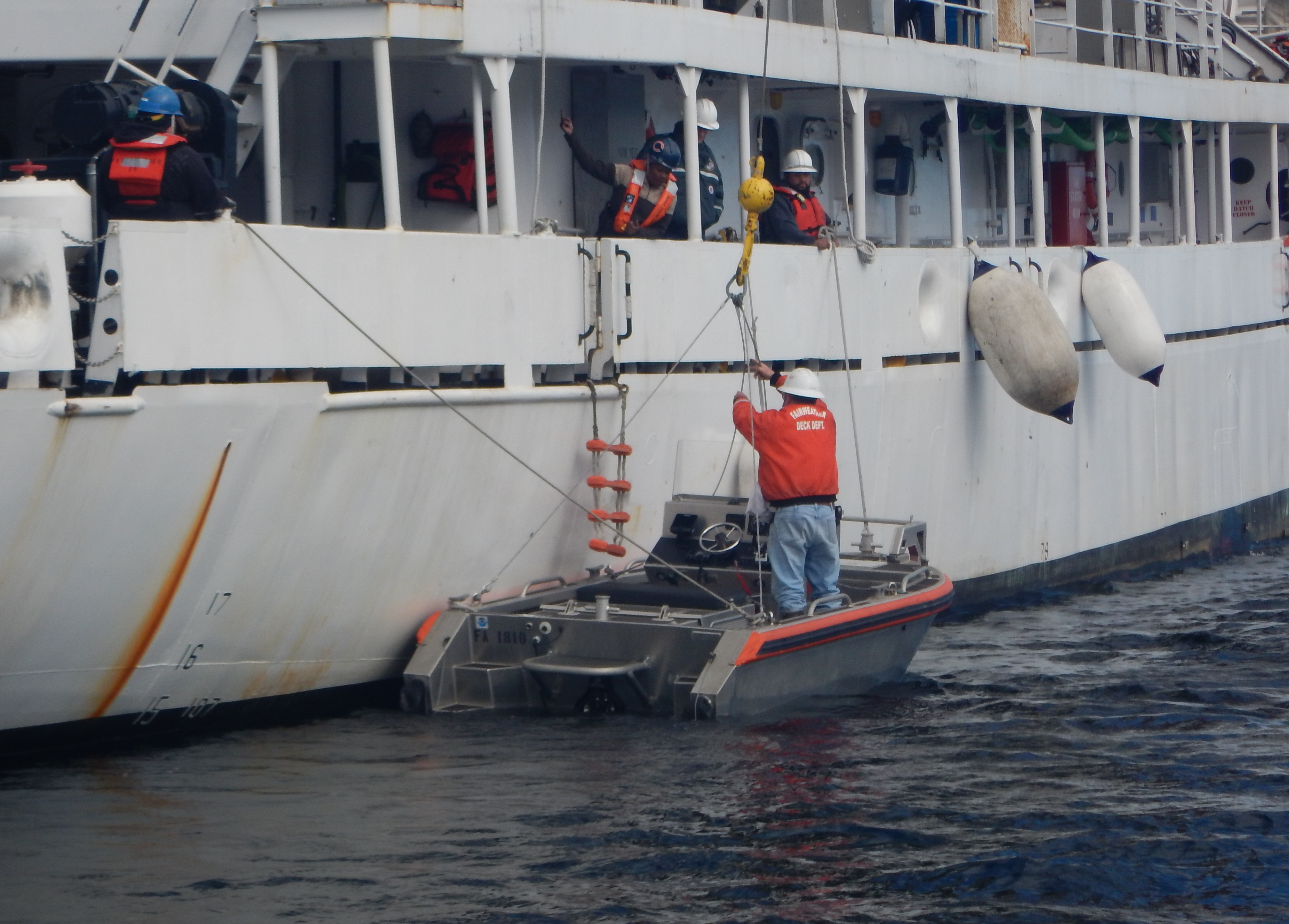 Crew members aboard NOAA Ship Fairweather prepare to recover a skiff