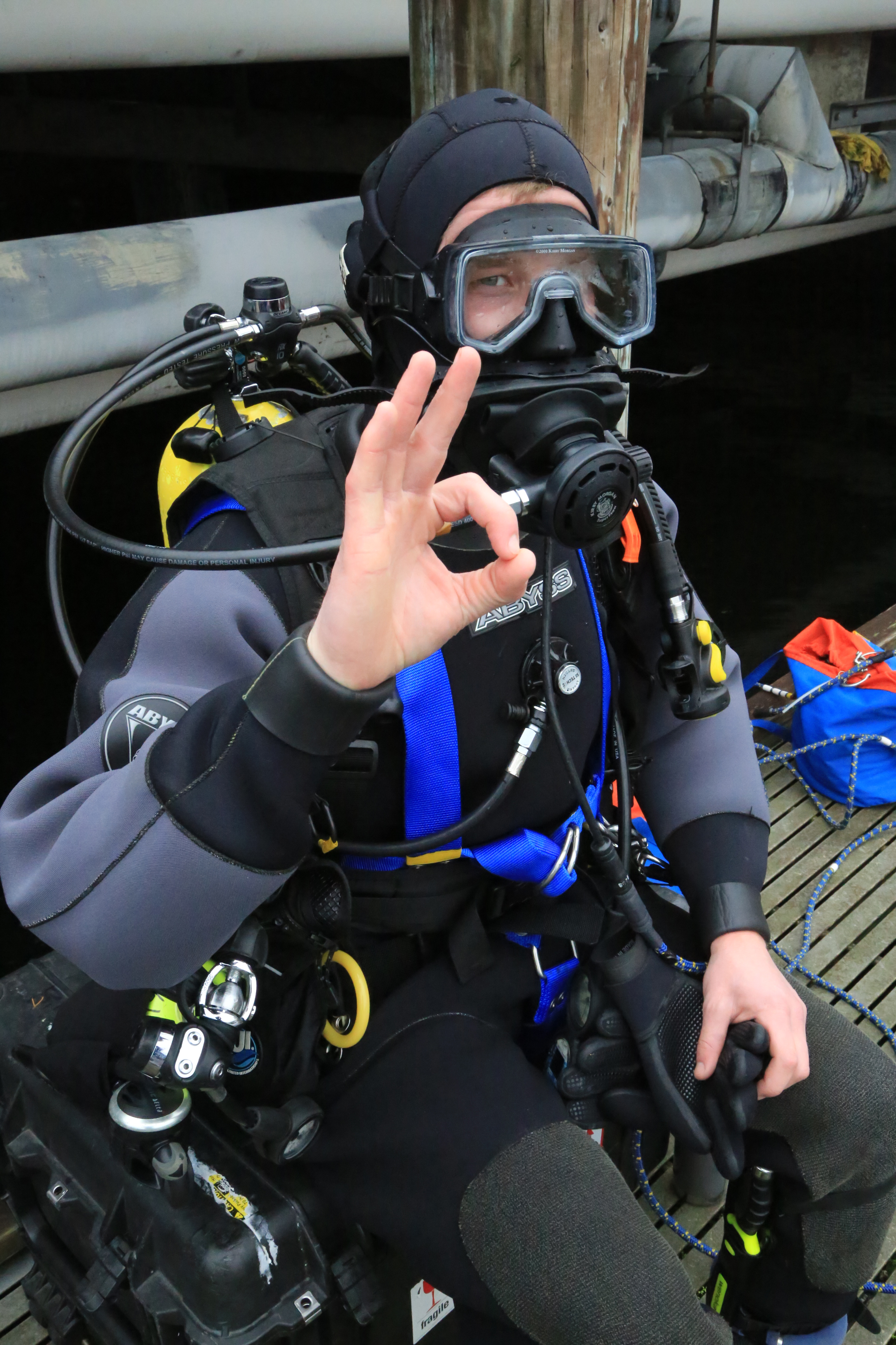 Tethered comms safety diver A student outfitted with tethered communications equipment gives the OK sign