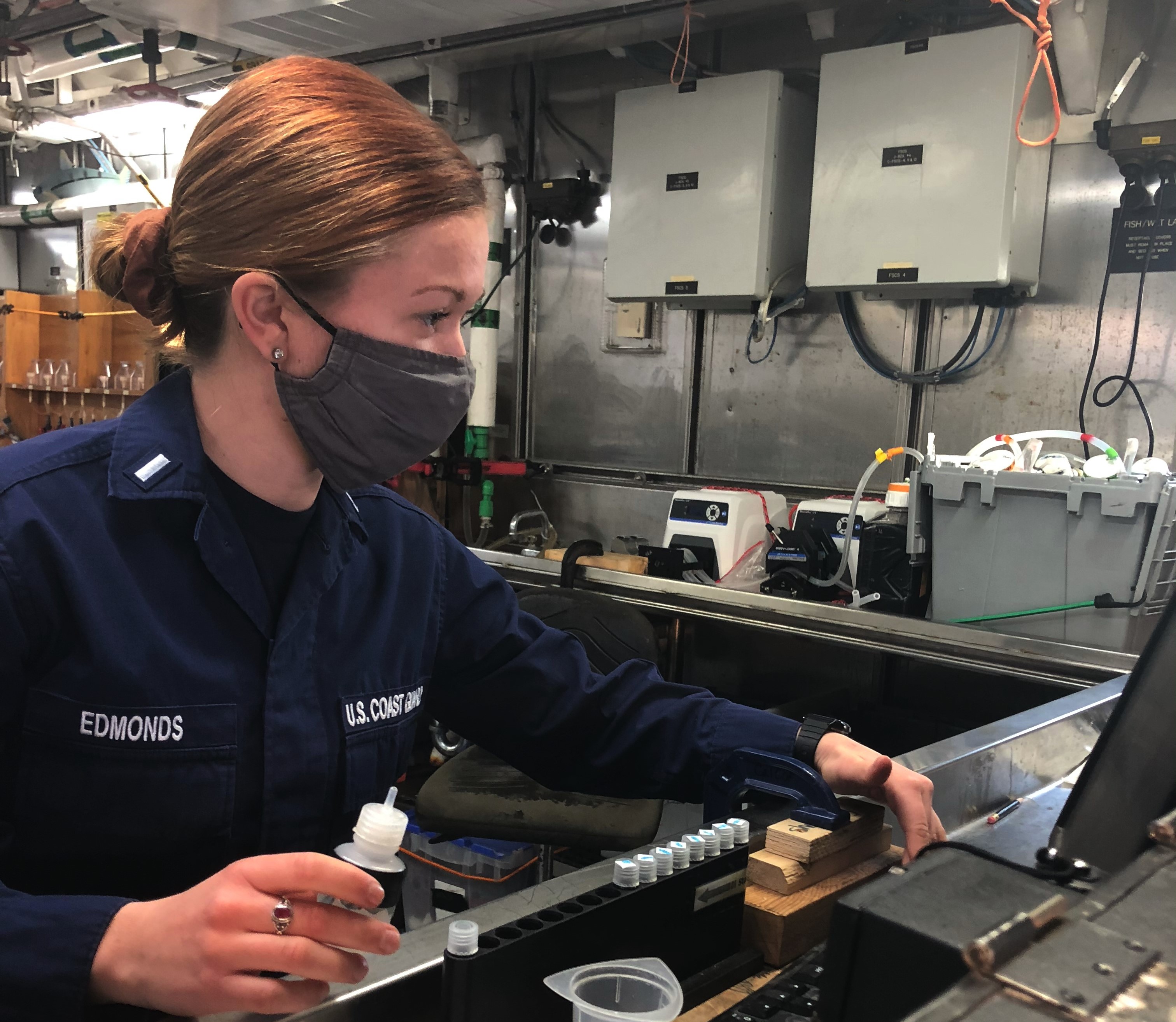U.S. Coast Guard officer Lt. j.g. Rebecca Edmonds uses a fluorometer aboard NOAA Ship Reuben Lasker to test the water samples fo