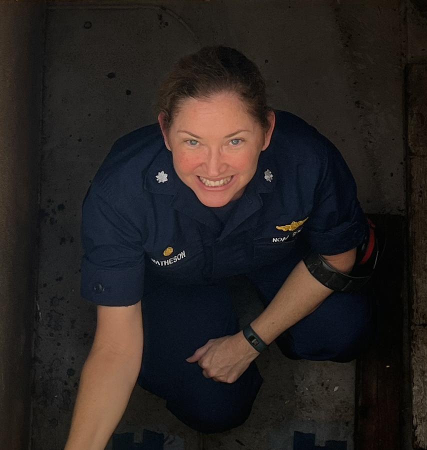 A female NOAA Corps officer in a stairwell aboard a ship