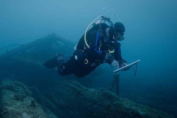 A NOAA scuba diver studies a shipwreck