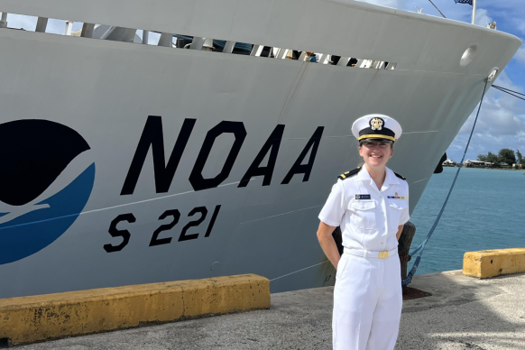 A NOAA Corps officer standing in front of NOAA Ship Rainier