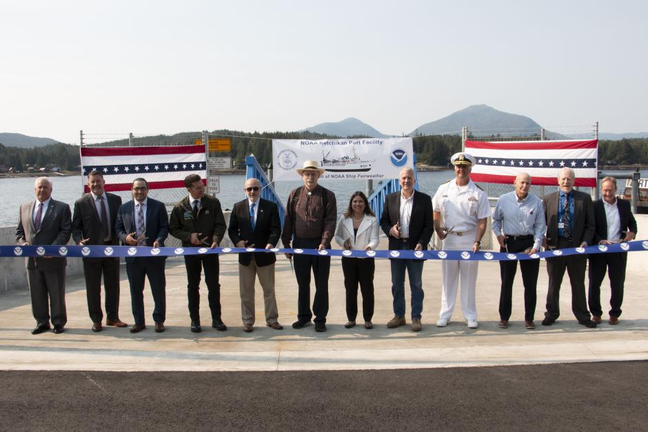 A long line of special guests, including NOAA Administrator Dr. Rick Spinrad (5th from the left), participate in a ribbon-cutting ceremony for the NOAA-renovated port facility in Ketchikan, Alaska, on August 21, 2023.