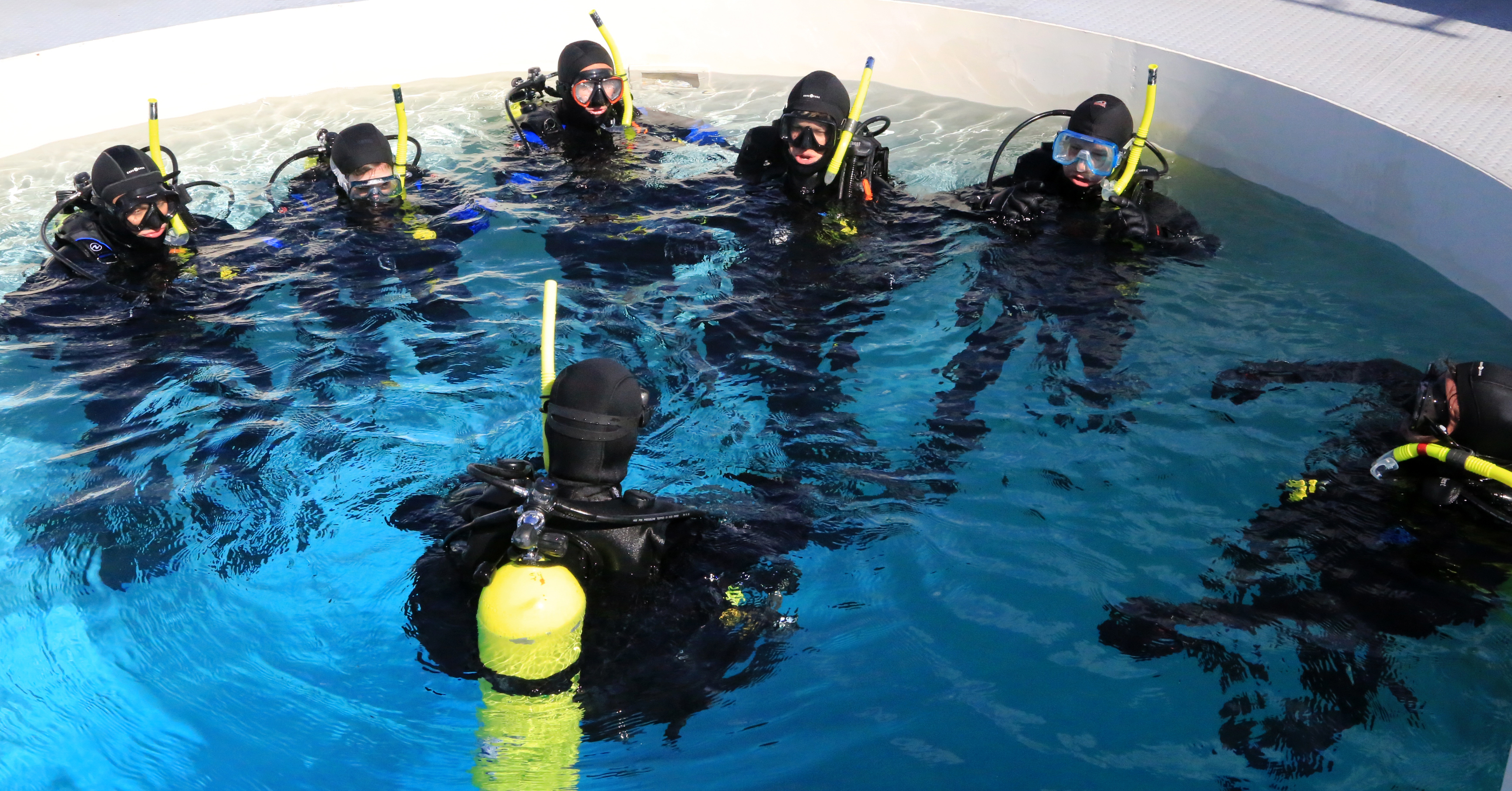 Students and instructor on the surface of the NOAA Diving Center training tank.