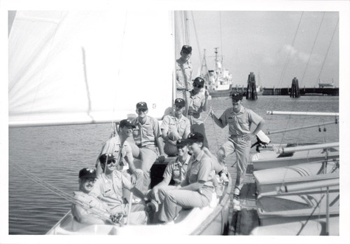 The graduates of BOTC 45 are seated in a small boat alongside a dock.