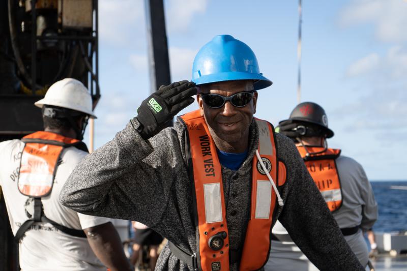 A professional mariner aboard a NOAA ship saluting the camera