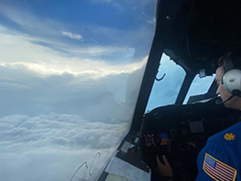 The eye of a hurricane and a pilot as seen from the flight station of a NOAA aircraft