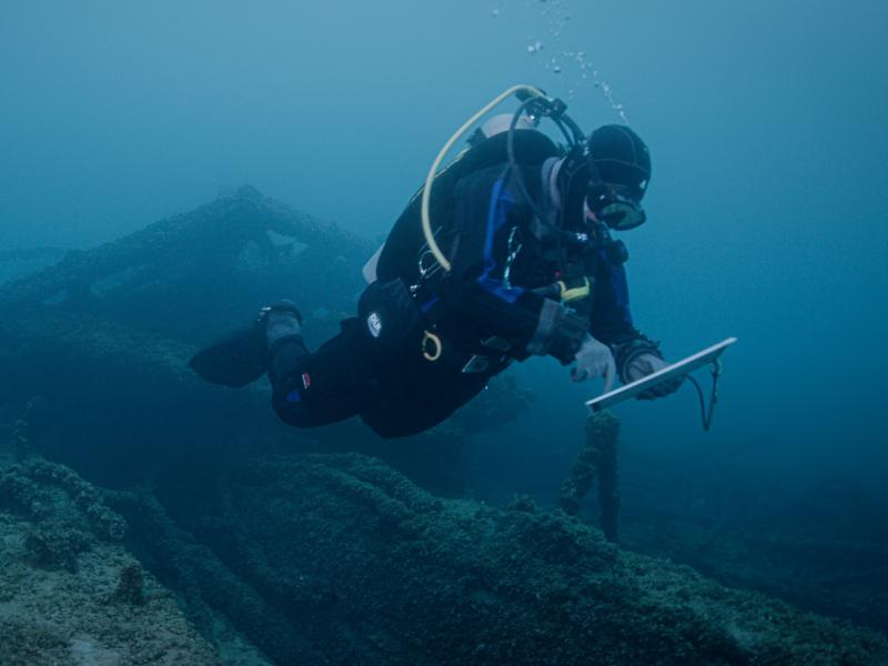 A NOAA scuba diver studies a shipwreck