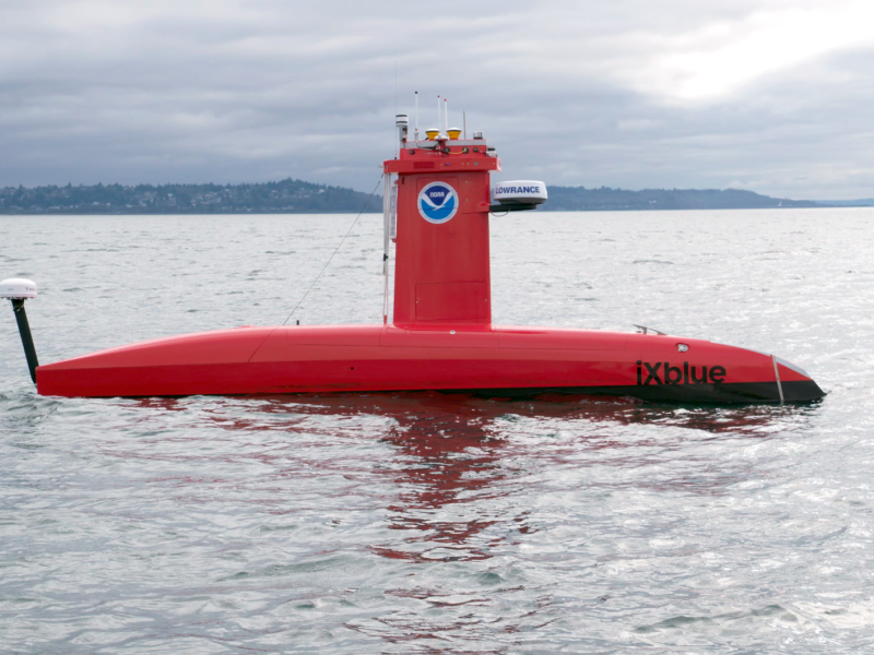 A bright orange uncrewed surface vessel floating on the water