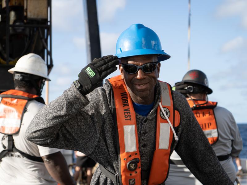 A professional mariner aboard a NOAA ship saluting the camera