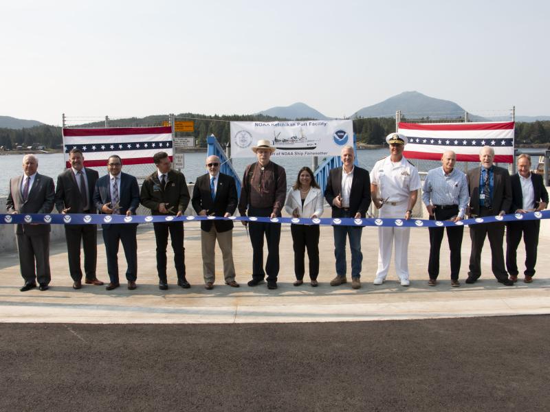 A long line of special guests, including NOAA Administrator Dr. Rick Spinrad (5th from the left), participate in a ribbon-cutting ceremony for the NOAA-renovated port facility in Ketchikan, Alaska, on August 21, 2023.