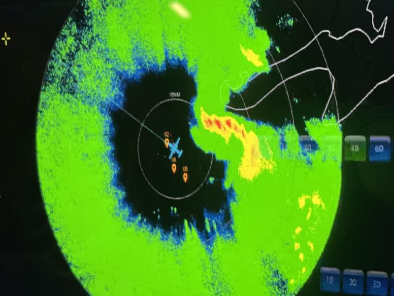 Radar display showing NOAA aircraft in middle of a ring of green and yellow.