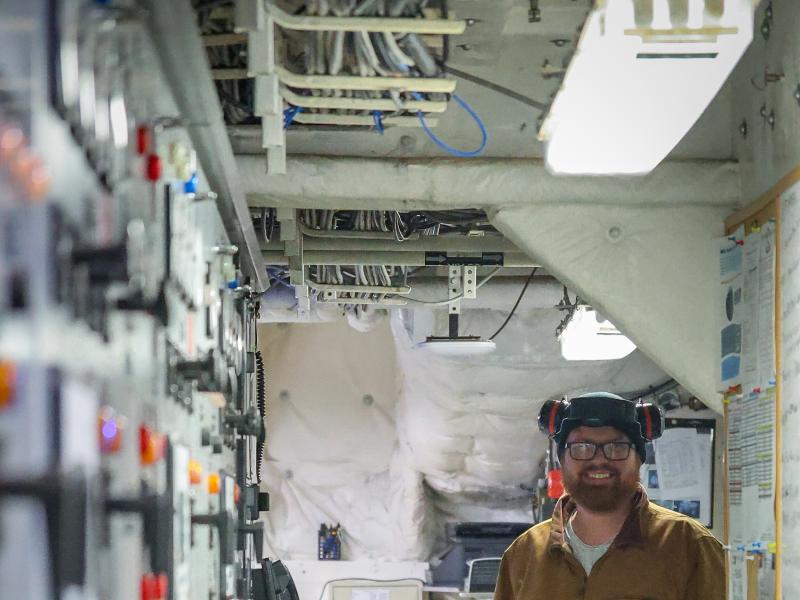 An engineer stands in the engineering operating space aboard a NOAA ship
