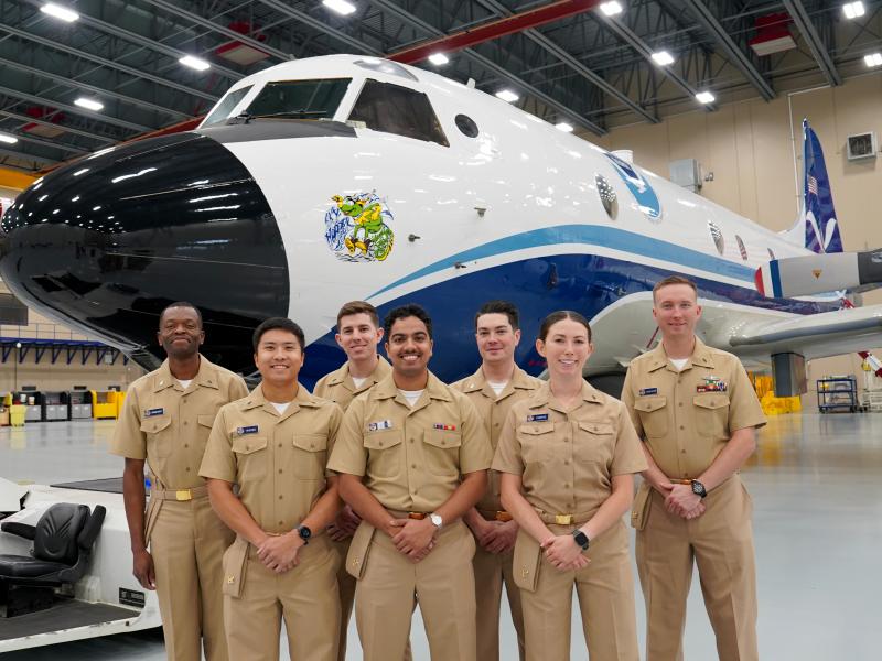 NOAA Commissioned Officer Corps pilots stand in front of NOAA WP-3D Orion "Kermit" during their tour of the NOAA Aircraft Operations Center in Lakeland, FL.(From L to R): Ensigns Ghislain Martial Ngangnang Ngangte, Wally Wilbowo, Christian Eden, Brian D'Souza, James Seibert, Sara Towers, Dylan Legus-Sleigh