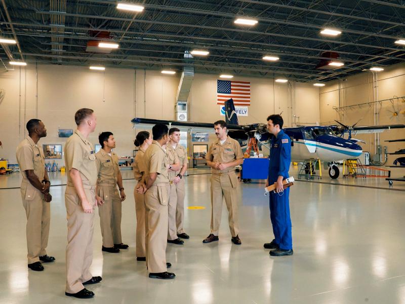 Lt. Eric Fritzsche and Ensign Davis Benningfield lead new NOAA Commissioned Officer Corps on a tour through the light aircraft hangar at the NOAA Aircraft Operations Center.