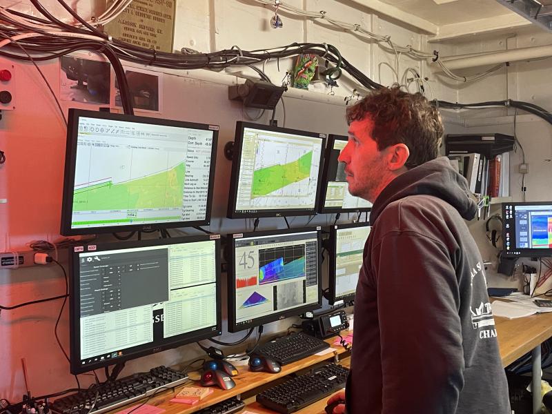 A survey technician monitors data collection aboard a NOAA ship