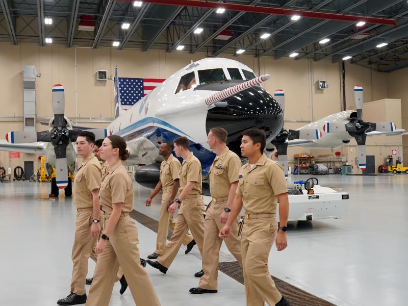 NOAA Commissioned Officer Corps pilots walk through the hangar during their tour of the NOAA Aircraft Operations Center in Lakeland, Fla.