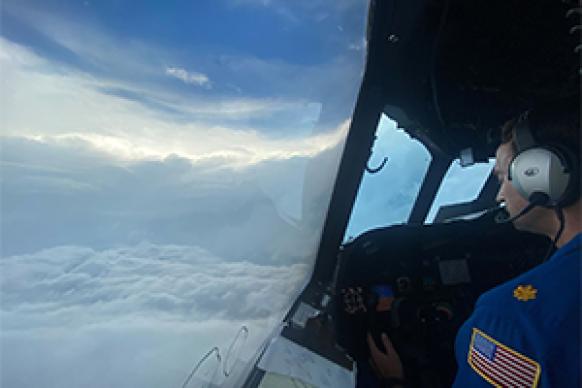 The eye of a hurricane and a pilot as seen from the flight station of a NOAA aircraft