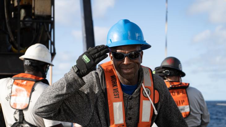 A professional mariner aboard a NOAA ship saluting the camera