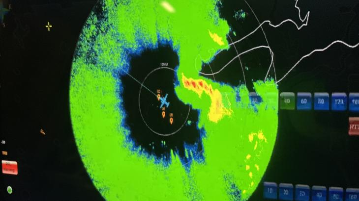 Radar display showing NOAA aircraft in middle of a ring of green and yellow.