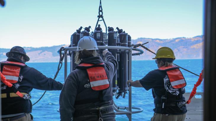NOAA ship crew with an oceanographic instrument