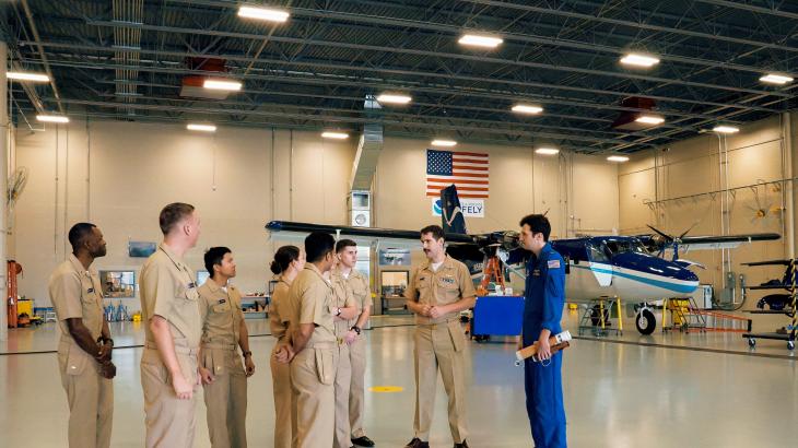 Lt. Eric Fritzsche and Ensign Davis Benningfield lead new NOAA Commissioned Officer Corps on a tour through the light aircraft hangar at the NOAA Aircraft Operations Center.