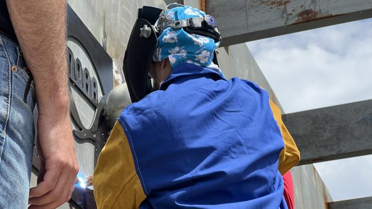 RDML Amanda Goeller welds NOAA plaque onto pier