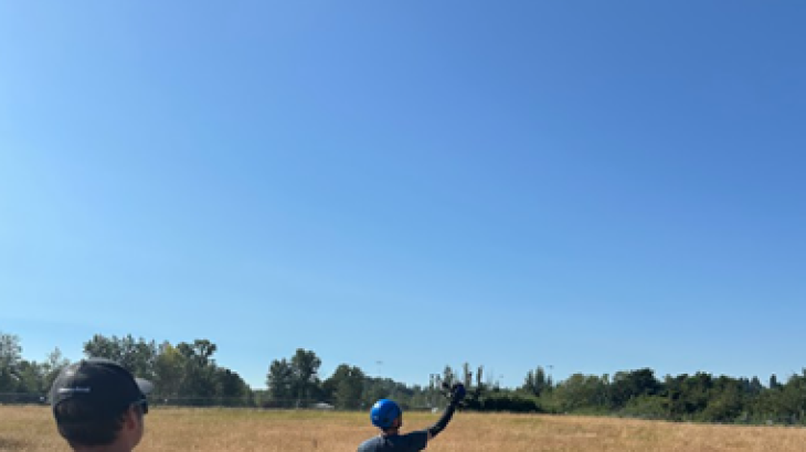 In a training session, an uncrewed aircraft operator pilots a platform as somone in the distance catches it.